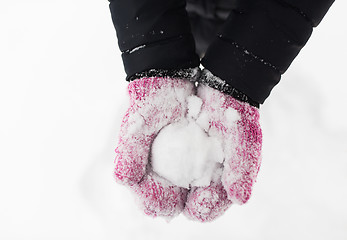 Image showing close up of woman holding snowball outdoors