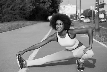Image showing Portrait of sporty young african american woman stretching outdo