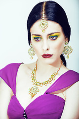 Image showing young pretty caucasian woman like indian in ethnic jewelry close up on white, bridal makeup