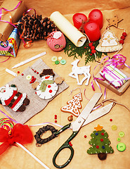 Image showing handmade christmas gifts in mess with toys, candles, fir, ribbon, post card view decorated