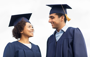 Image showing happy students or bachelors in mortar boards