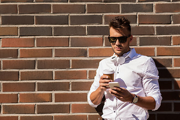 Image showing man with smartphone and coffee cup on city street