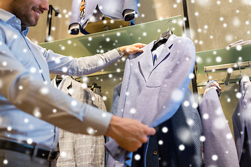 Image showing close up of man choosing jacket at clothing store