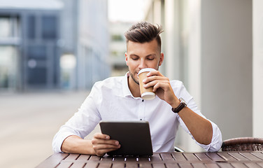 Image showing man with tablet pc and coffee at city cafe