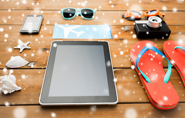 Image showing tablet pc, airplane ticket and beach stuff