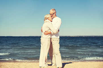 Image showing happy senior couple hugging on summer beach