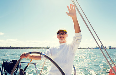 Image showing senior man at helm on boat or yacht sailing in sea