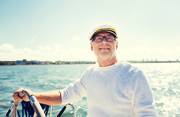 Image showing senior man at helm on boat or yacht sailing in sea