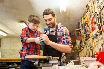 Image showing father and son with drill working at workshop