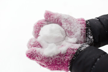 Image showing close up of woman holding snowball outdoors