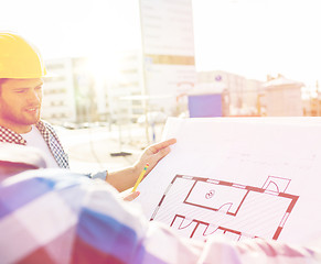 Image showing close up of builders with blueprint at building