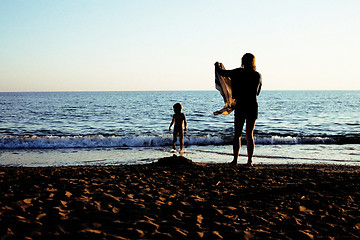 Image showing young mother with son resting on sea coast, happy family togethe