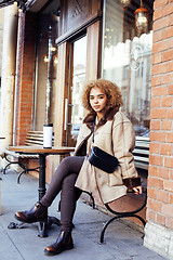 Image showing young pretty african american women drinking coffee outside in c