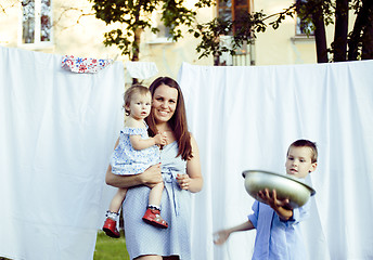 Image showing woman with children in garden hanging laundry outside, lifestyle
