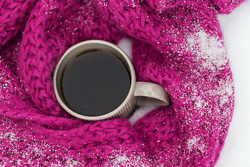 Image showing close up of tea or coffee and winter scarf in snow