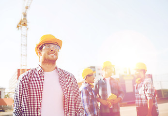 Image showing group of smiling builders in hardhats outdoors