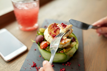 Image showing woman eating goat cheese salad at restaurant