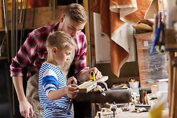 Image showing father and son with ruler measure wood at workshop