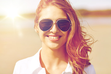 Image showing smiling young woman in sunglasses on beach