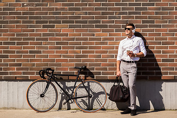 Image showing man with headphones, smartphone and bicycle
