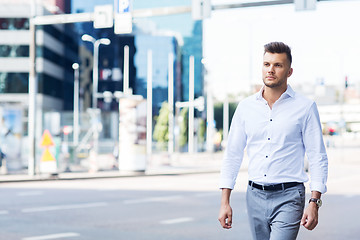 Image showing young man walking along city street