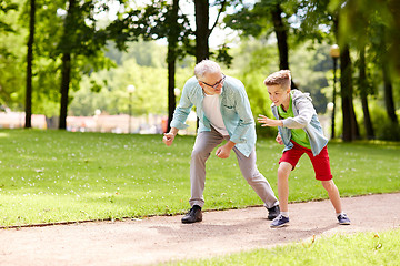 Image showing grandfather and grandson racing at summer park