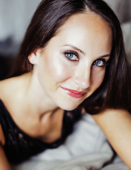 Image showing pretty young brunette woman in bedroom interior smiling