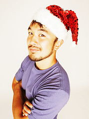 Image showing funy exotical asian Santa claus in new years red hat smiling