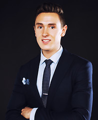 Image showing young pretty business man standing on black background, modern h