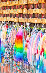 Image showing Ema prayer tablets and strings of paper origami cranes. Wishes written in Japanese on the plaques.