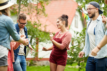 Image showing happy friends dancing at summer party in garden