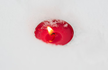 Image showing burning christmas candle on snow in winter