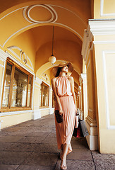 Image showing young pretty smiling woman in hat with bags on shopping at store