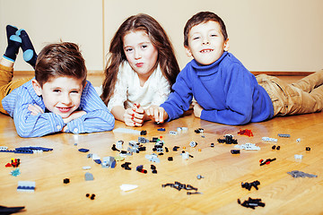 Image showing funny cute children playing lego at home, boys and girl smiling, first education role lifestyle