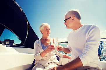 Image showing senior couple clinking glasses on boat or yacht