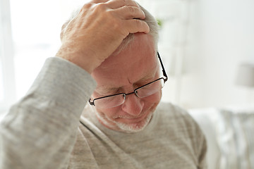 Image showing senior man suffering from headache at home