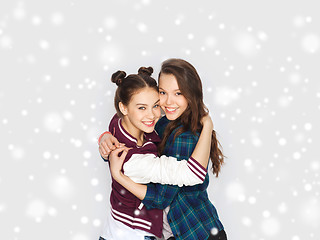 Image showing happy smiling teenage girls hugging over snow