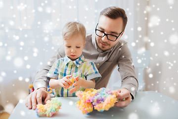 Image showing father and son playing with ball clay at home