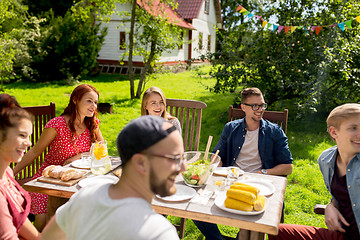 Image showing happy friends having dinner at summer garden party