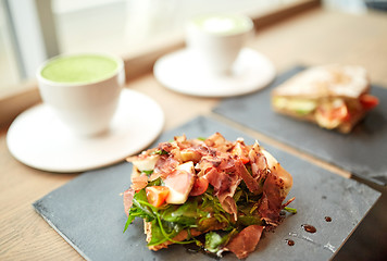 Image showing prosciutto ham salad on stone plate at restaurant