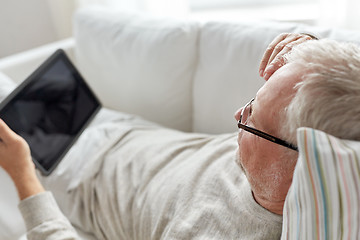 Image showing senior man with tablet pc lying on sofa at home