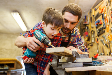 Image showing father and son with drill working at workshop