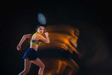 Image showing Portrait of beautiful girl tennis player with a racket on dark background