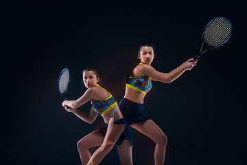 Image showing Portrait of beautiful girl tennis player with a racket on dark background
