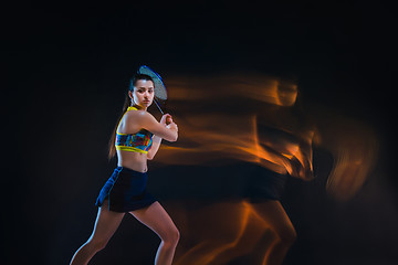 Image showing Portrait of beautiful girl tennis player with a racket on dark background