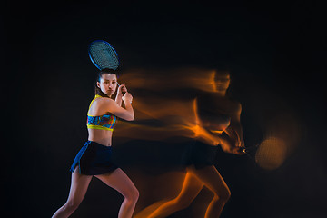 Image showing Portrait of beautiful girl tennis player with a racket on dark background