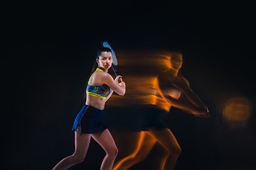 Image showing Portrait of beautiful girl tennis player with a racket on dark background