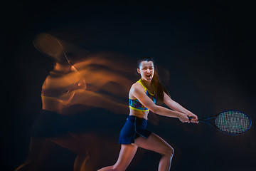 Image showing Portrait of beautiful girl tennis player with a racket on dark background