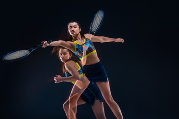 Image showing Portrait of beautiful girl tennis player with a racket on dark background