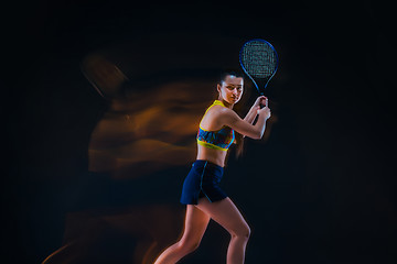 Image showing Portrait of beautiful girl tennis player with a racket on dark background